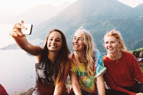 Three female friends taking smartphone selfie at Lake Atitlan, Guatemala