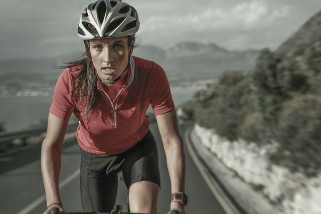 mujer ciclista sube un puerto de montaña