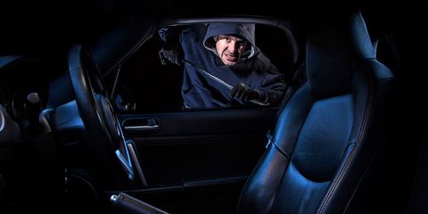 a man breaking into a parked car at night photo by loop imagesuniversal images group via getty images