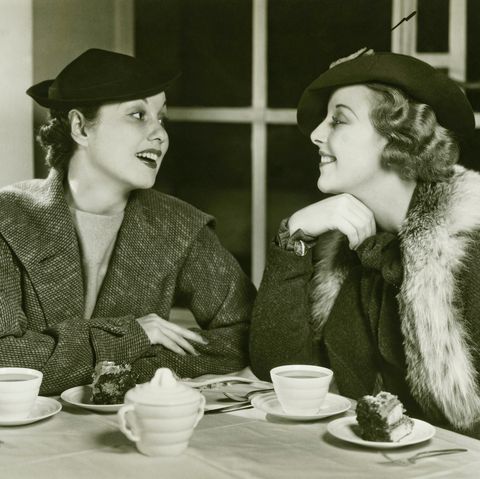 two young women chatting, having coffee and cake, bw