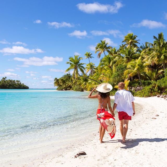couple walking along the beach in the cook islands