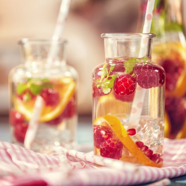 infused water with fresh raspberries, lemon, pomegranate and mint served in a glass jar