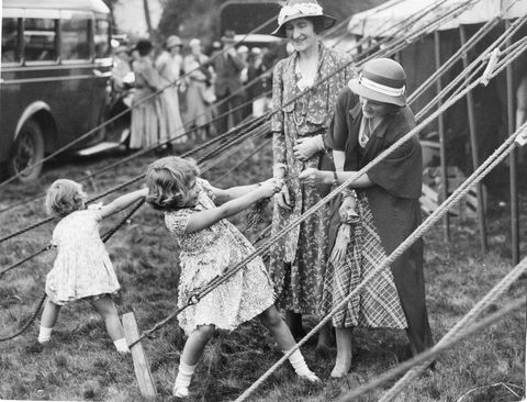 this charming snapshot, taken at the abergeldie castle fete, behind the marquee in which the two little princesses sold white heather in aid of the funds of crathie church, scotland, june 9, 1933 princess elizabeth is enjoying a tug of war with a spring of heather, while princess margaret rose busies herself with the guy ropes of the marquee photo by photoquestgetty images