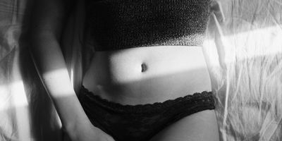 female in bed in panties in black and white filter being intimate masturbating