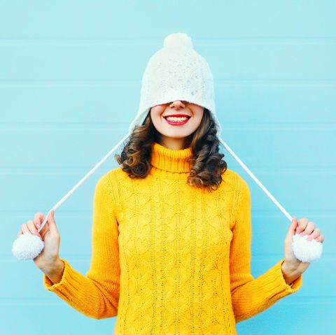 Fashion happy young woman in knitted hat sweater having fun