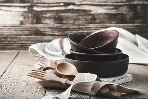 Simple crockery and wooden cooking utensils set on rustic table