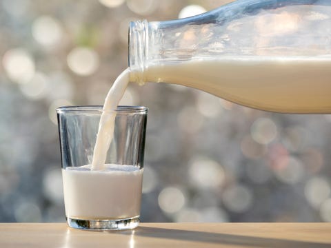 Bottle of milk of crystal filling a glass of milk, illuminated by the natural light of the Sun