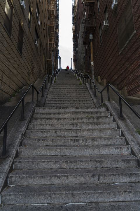 The long stairway goes through among the buildings at The Bronx New York.