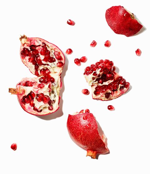 Pomegranate and seeds on white background