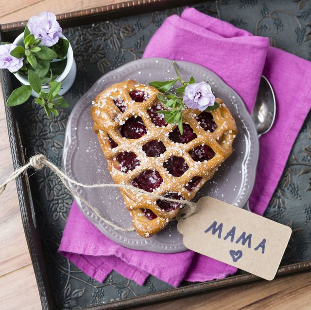 Heart-shaped cherry cake with name tag and flowers on tray