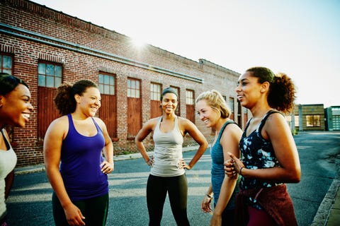 laughing group of women resting after morning run through city