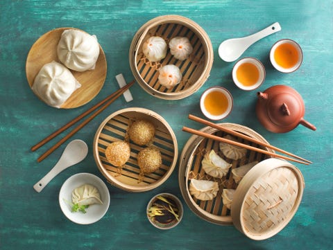 overhead view chinese food assorted dim sum food in bamboo steamer tray on rustic green table top chinese style breakfast with tea