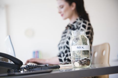401k money jar on desk of Caucasian businesswoman