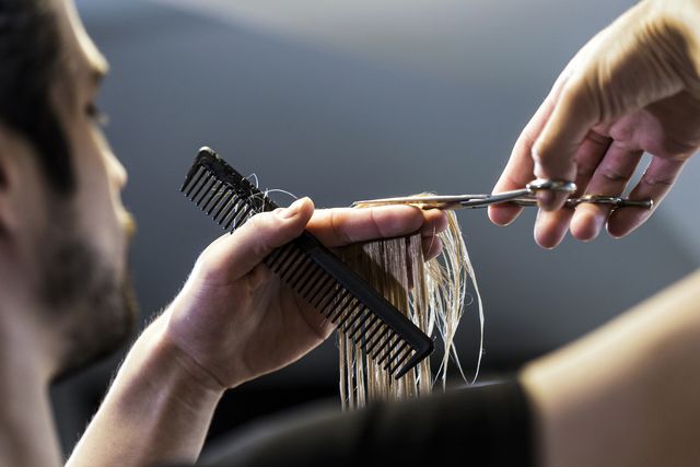hairdressers cutting hand with scissors and comb