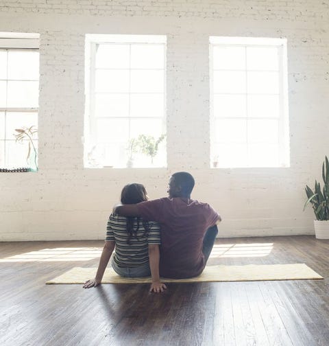 Young couple sitting on carpet in a loft