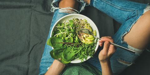 vegetarian breakfast bowl with spinach, arugula, avocado, seeds and sprouts