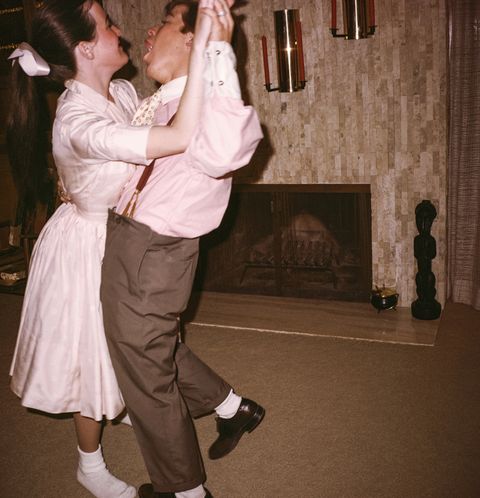 Caucasian man and woman dancing near fireplace