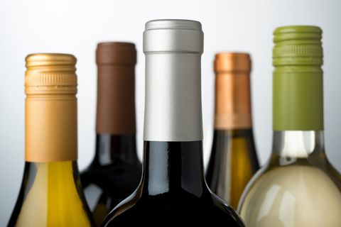 Close-Up Of Wine Bottles Against Gray Background