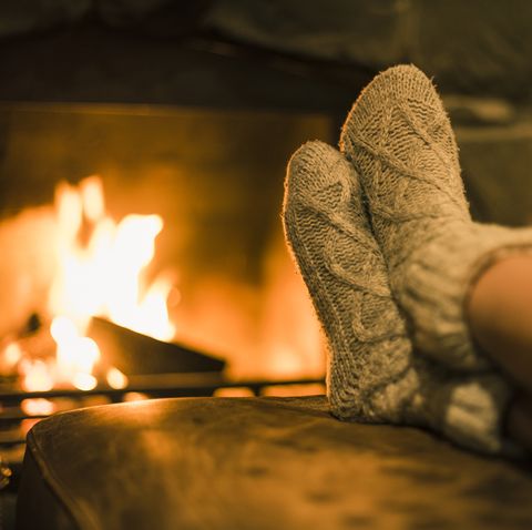 Feet in wool socks near fireplace