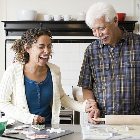 a father and daughter laughing while making cookies