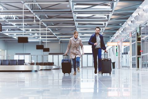 Young couple running towards boarding gate in airport