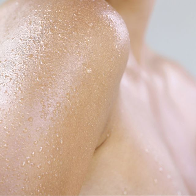 womans shoulder with drops of water on skin