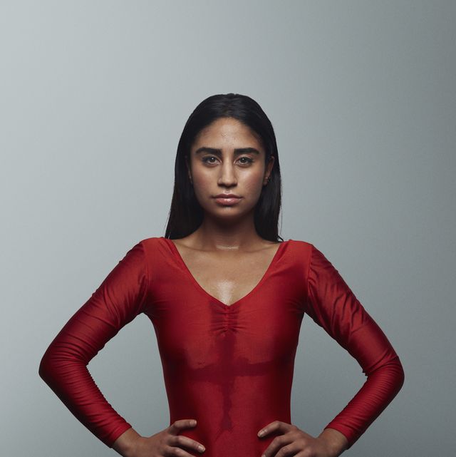 Cool female gymnast looking in camera, wearing leotard