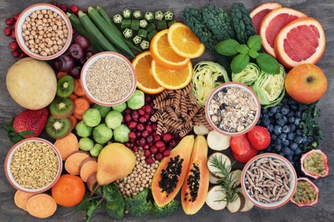 health food concept for a high fiber diet with fruit, vegetables, cereals, whole wheat pasta, grains, legumes and herbs foods high in anthocyanins, antioxidants, smart carbohydrates and vitamins on marble background top view