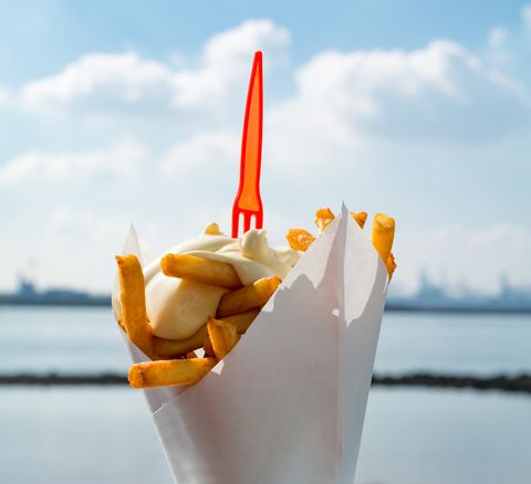 Dutch french fries from mashed potato with mayonaise and plastic fork on top