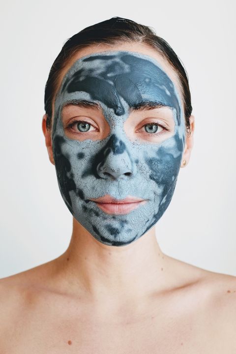 Portrait Of Young Woman With Facial Mask Against White Background