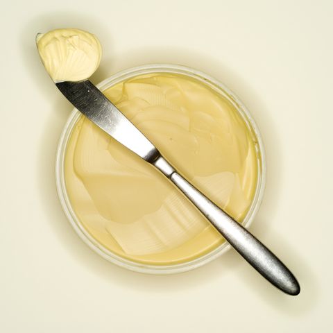 margarine curl lying on back of a knife, elevated view