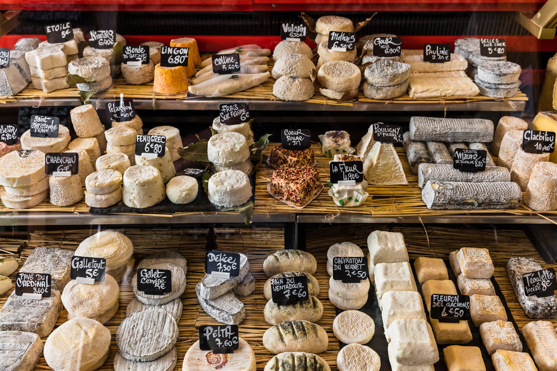 uma grande seleção de diferentes queijos franceses e italianos no balcão de uma pequena loja no aligre market marche daligre no distrito da bastilha paris, frança