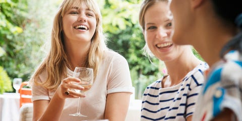 Women sitting on sofa, laughing talking and drinking wine. Women sitting on sofa, laughing talking and drinking wine.