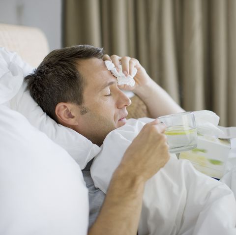 Man sick in bed with cold or flu