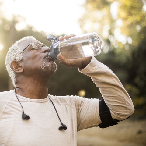 a senior african american man enjoying refreshing water after a workout