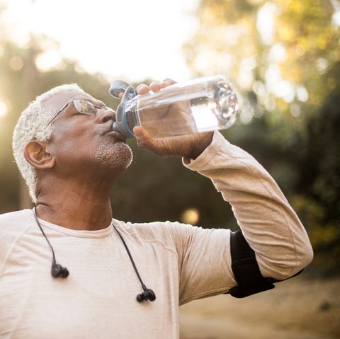 a senior african american man enjoying refreshing water after a workout