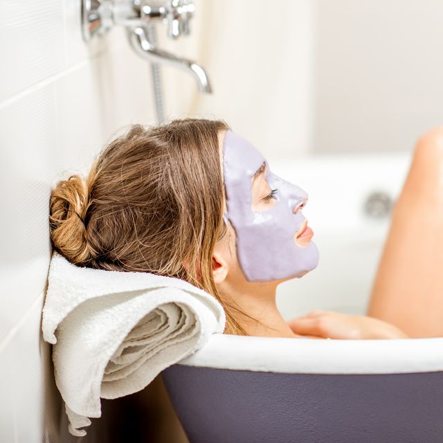 portrait of a woman in facial alginate mask lying in the retro bath in the bathroom
