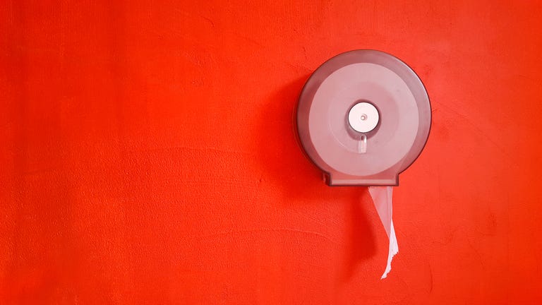 Toilet paper roll on red wall