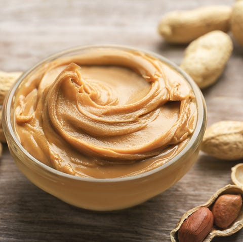 Glass bowl with peanut butter on wooden background Glass bowl with peanut butter on wooden background