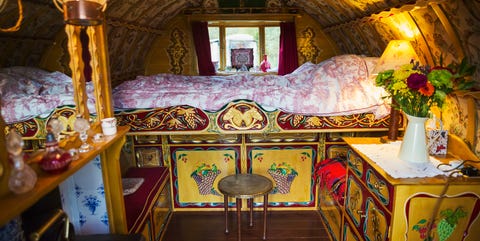 The interior of a traditional gypsy caravan with raised bed and cupboards, bow top roof and stove. The interior of a traditional gypsy caravan with raised bed and cupboards, bow top roof and stove.