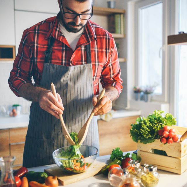 man preparing vegetable salad at home