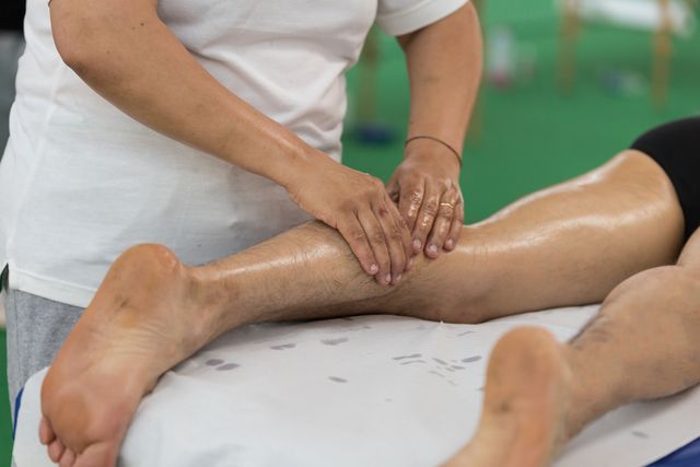 rimini, italy   june 2016 athletes calf muscle professional massage treatment after sport workout fitness and wellness during annual fitness festival in rimini named rimini fitness festival