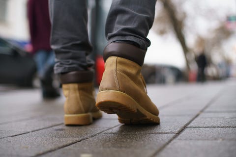 Close-up of a mans legs walking on the pavement