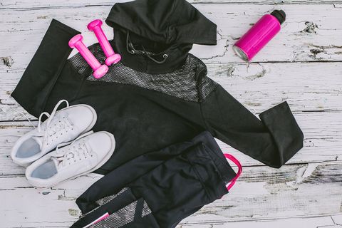 Flat lay shot of woman Sport equipment, shoes, water, earphone and phone on wooden background