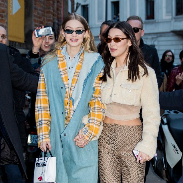 milan, italy   february 21 gigi hadid wearing denim vest, tartan jacket, denim button shirt and  bella hadid wearing cropped top and jacket, silk pants seen outside alberta ferretti during milan fashion week fallwinter 201819 on february 21, 2018 in milan, italy photo by christian vieriggetty images
