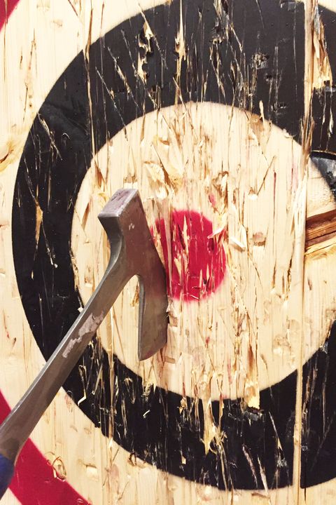 a large metal ax is embedded into a wooden target while playing the game of axe throwing
