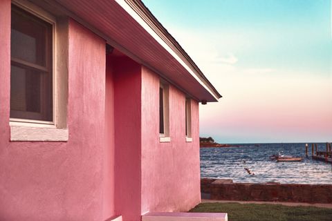 pink beach house with lawn near the atlantic sea with beautiful color gradient sky