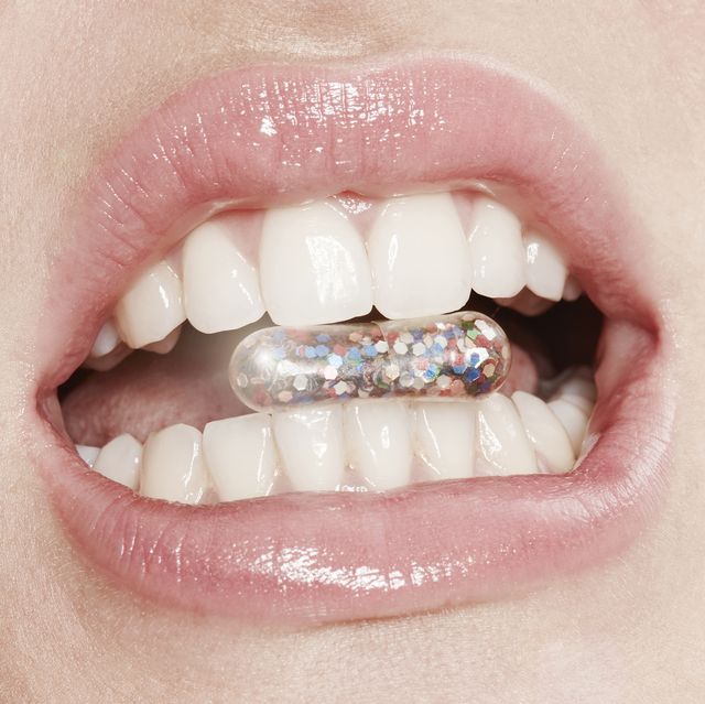 Lips of woman taking glitter capsule