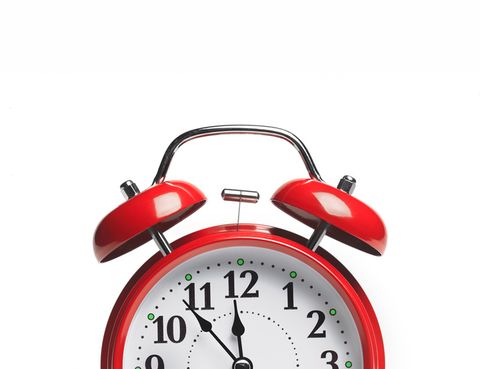 bell alarm clock showing five minutes to 12