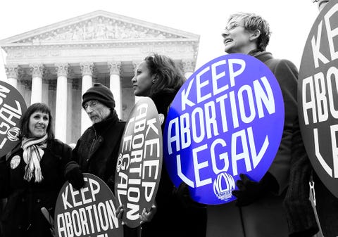 woman holding a sign that says keep abortion legal